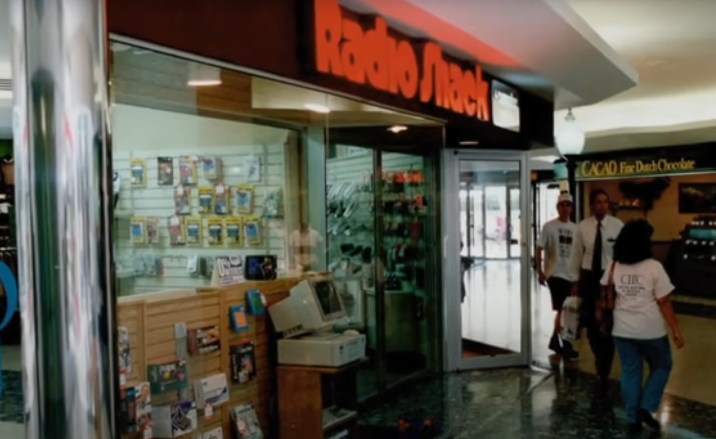 Shoppers saunter past a Radio Shack. 
